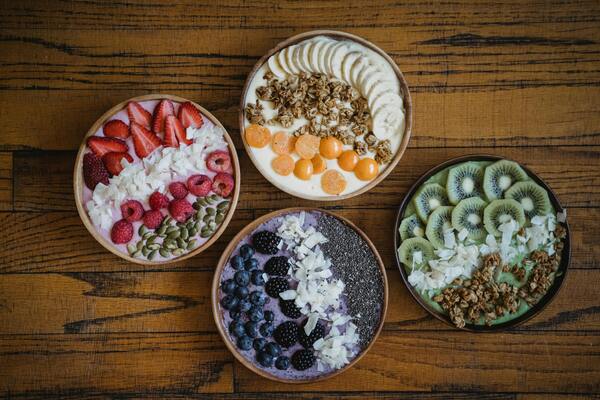 A person adding fresh berries and microgreens to their morning oatmeal.
